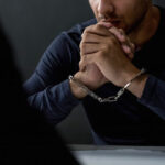 A man with his hands chained up.